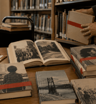 Libros de no ficción censurados en una biblioteca escolar con cintas rojas sobre sus portadas.