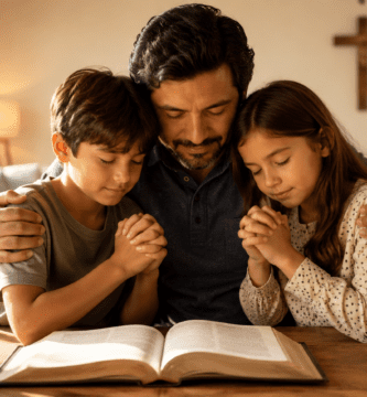 Padre orando con sus hijos junto a una Biblia para agradecer a Dios por su vida