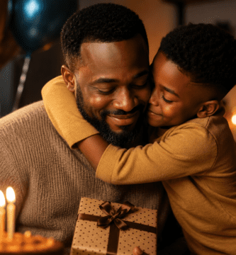 Padre afrodescendiente recibiendo un abrazo de su hijo durante la celebración de su cumpleaños