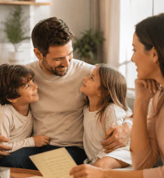 Esposa leyendo una carta poema mientras su esposo sonríe con sus hijos en casa, imagen familiar para poemas largos del Día del Padre.