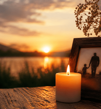 Vela encendida junto a una foto de papá y su hijo al atardecer para recordar a un padre fallecido en el Día del Padre