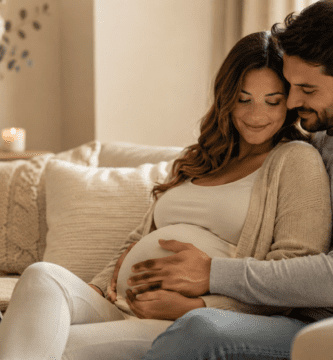 Pareja esperando un bebé en casa, futuro papá acariciando el vientre de la mamá embarazada en un momento tierno del Día del Padre.