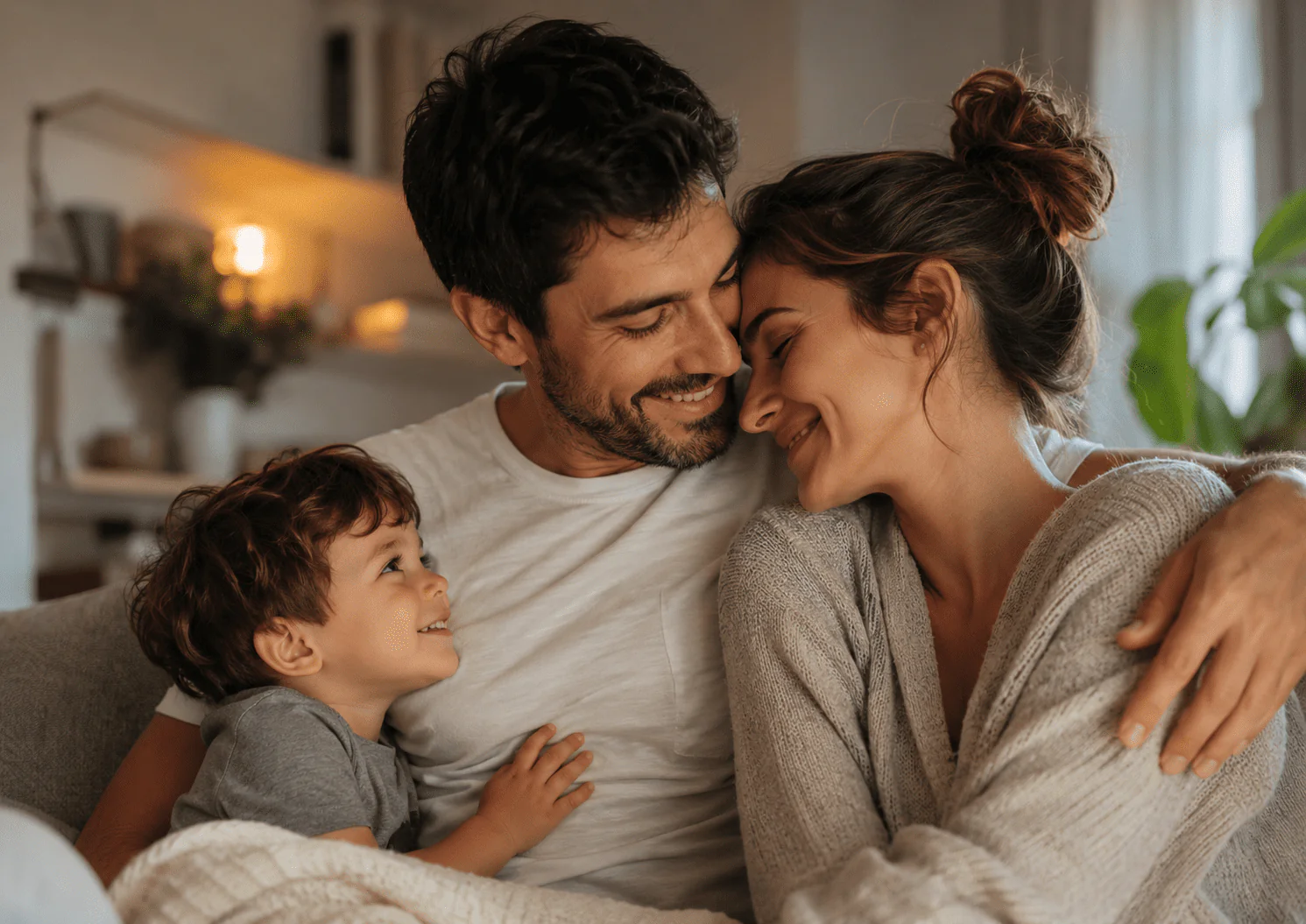 Pareja abrazada con un niño en casa, escena familiar para poemas en el Día del Padre.