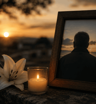 Foto de recuerdo de papá fallecido con vela encendida y flores blancas al atardecer