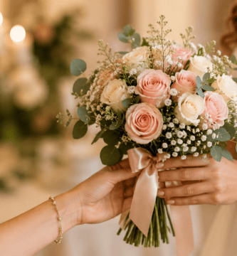 Manos entregando un ramo de novia con rosas blancas y rosadas durante un momento emotivo antes de la ceremonia.