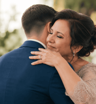 Madre abrazando emocionada a su hijo el día de su boda, en una escena cálida y familiar llena de orgullo y ternura.