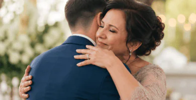 Madre abrazando emocionada a su hijo el día de su boda, en una escena cálida y familiar llena de orgullo y ternura.